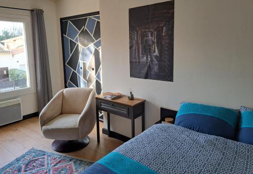 a bedroom with a bed and a chair and a desk at Chambre Cassis in Arles