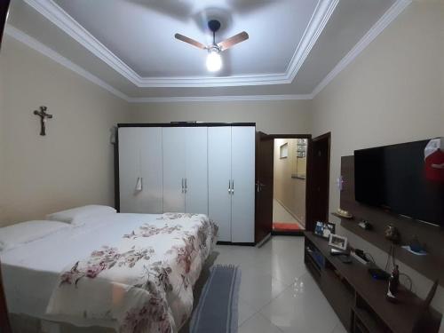 um quarto com uma cama e uma ventoinha de tecto em Casa Localizado no Centro de Guape MG em Guapé