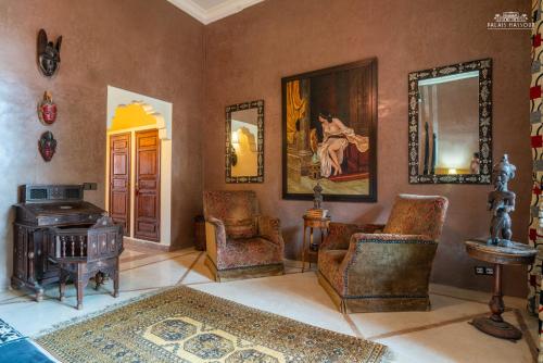 a living room with chairs and a table and a mirror at Palais Hassoun Marrakech in Oulad Snaguia