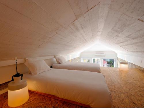 ポルトにあるLargo São Domingos by Innapartmentsのライト付きの部屋の白いベッド2台