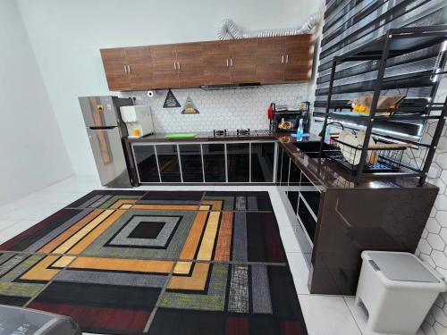 a kitchen with a large rug on the floor at Pangeran Homestay Pokok Sena in Kampong Joo