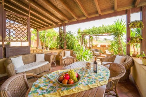 un tavolo con un cesto di frutta su un patio di Casa Belìce a Marinella di Selinunte