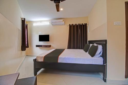 pokój hotelowy z łóżkiem i telewizorem w obiekcie Super OYO Flagship Rsd Grand w mieście Gunadala