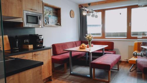 uma pequena cozinha com mesa e cadeiras num quarto em Appartement Alpenrauschen em Planneralm