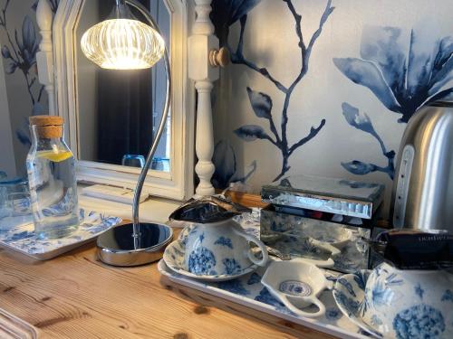 a table with blue and white vases and a mirror at Abbey Green Farm in Wem