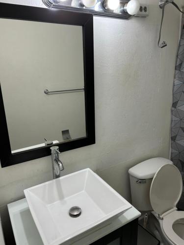 y baño con lavabo, espejo y aseo. en MARVELOUS APARTMENT, en San Juan