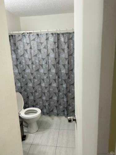 y baño con aseo y cortina de ducha. en MARVELOUS APARTMENT, en San Juan