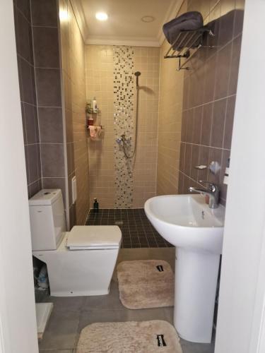 a bathroom with a toilet and a sink and a shower at Deegii's house in Ulaanbaatar