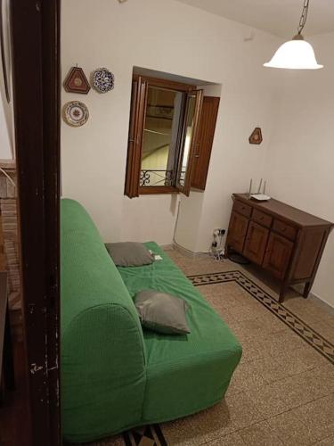 a green bed in a room with a mirror at La Casa nel Borgo in Stimigliano