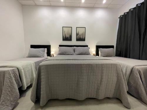 2 camas en una habitación con paredes blancas en VILLA BILAC 03 - Studio próximo à Vila Germânica en Blumenau