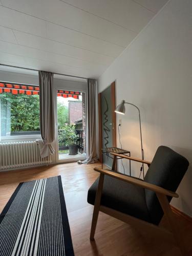 ein Wohnzimmer mit einem Schreibtisch und einem Stuhl in der Unterkunft Aussergewöhnliches Haus mit Sauna, Kamin und Garten in Wilhelmshaven