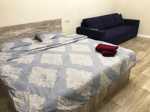 a bedroom with a bed and a blue couch at Asaapart Al-Farabi 131/8 in Almaty