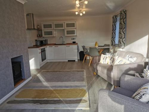 a living room with a couch and a kitchen at The Annexe in Swanton Morley. in Swanton Morley