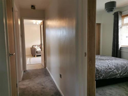 a bedroom with a bed and a door leading to a living room at The Annexe in Swanton Morley. in Swanton Morley