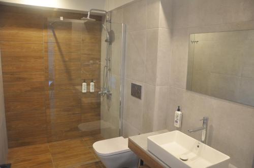 a bathroom with a shower and a toilet and a sink at Costa Ionica · Mytikas Seaside Hotel in Mitika