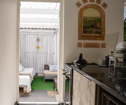 een keuken met een open deur naar een woonkamer bij Nirvana Cottage in Kaapstad