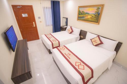 2 camas en una habitación de hotel con TV en Volga Hotel en Vung Tau