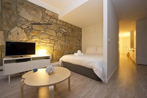 a hotel room with a bed and a tv at Largo São Domingos by Innapartments in Porto