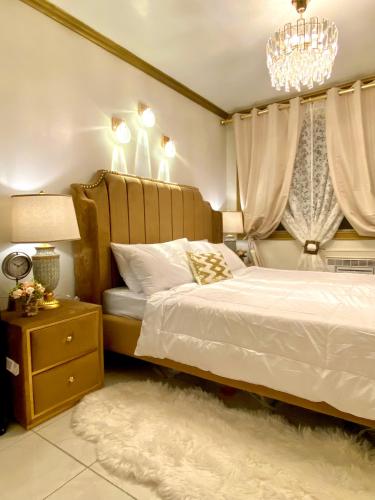 a bedroom with a bed and a chandelier at RK Maisson Roiyale Pasig in Manila