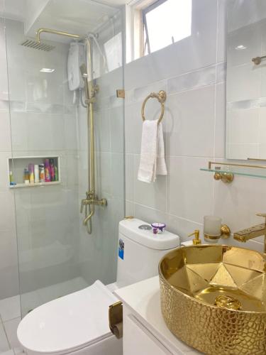 a bathroom with a sink and a toilet and a shower at RK Maisson Roiyale Pasig in Manila