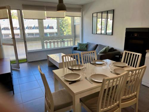un salon avec une table, des chaises et un canapé dans l'établissement L Altitude 3 pièces centre station moderne et rénové, à Les Deux Alpes