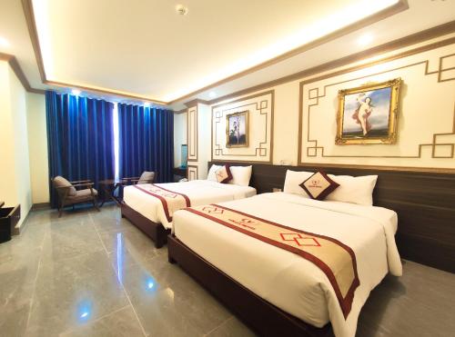 2 camas en una habitación de hotel con cortinas azules en Volga Hotel en Vung Tau