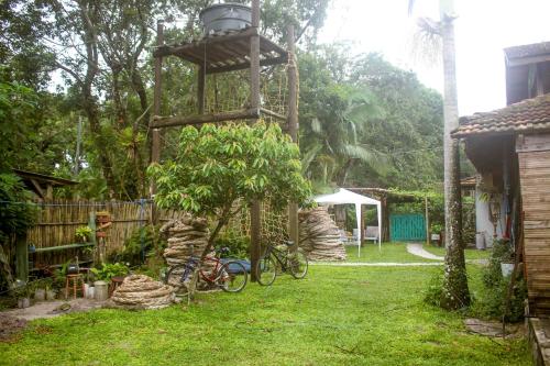 um jardim com duas bicicletas e uma luz num poste em Quartos Casa da Ilha do Mel - Nova Brasília na Ilha do Mel