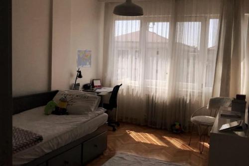 a bedroom with a bed and a desk in front of a window at Comfortable accommodation and nearby attractions in Istanbul