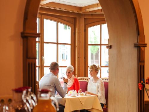 a group of people sitting at a table in a restaurant at Hotel und Restaurant Piccolo in Thale
