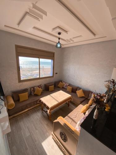 uma sala de estar com um sofá e uma mesa em Amouage Surf House Anza em Agadir