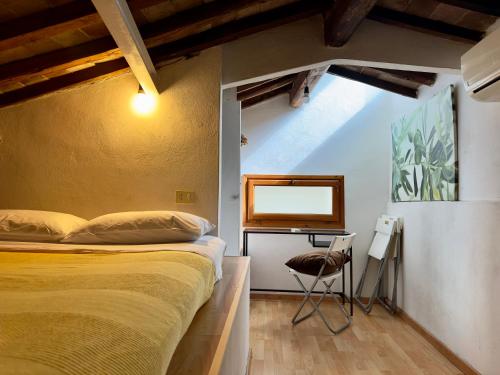 um quarto com uma cama e uma mesa com uma cadeira em Magnificat's Apartment em Florença