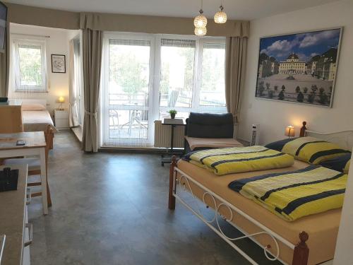 1 dormitorio con 2 camas, escritorio y ventana en Ludwig Apartment, en Ludwigsburg