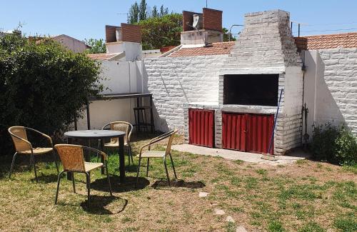a table and chairs in a yard with a building at Casa Familiar para hasta 6 personas , Lujan de Cuyo , Mendoza in Ciudad Lujan de Cuyo