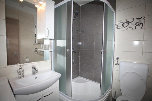 bagno con doccia, lavandino e servizi igienici di Apartments Villa Vetma a Kaštela (Castelli)