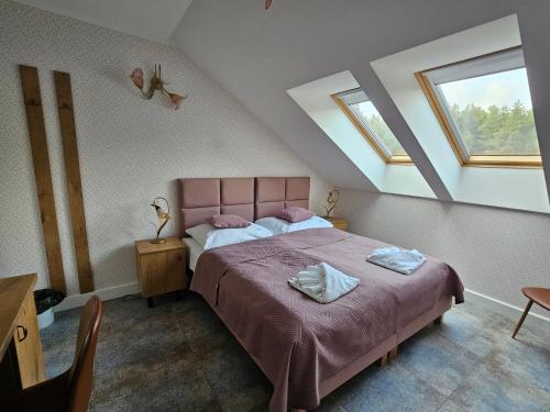 a bedroom with a pink bed with two towels on it at Dolcevita Podlasie in Bondary