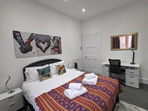 um quarto com uma cama com toalhas em The Summit West End- Elegant Apartment with Free Parking in Prime Location em Aberdeen