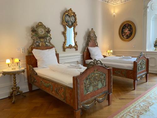 a bedroom with two beds and a mirror on the wall at Schloss Langenzell, Fürstensuite in Wiesenbach
