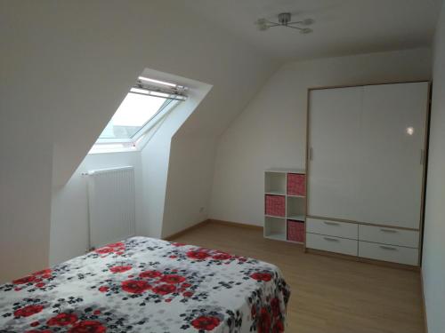 ein Schlafzimmer mit einem Bett mit einer Blumendecke und einem Fenster in der Unterkunft chambre d'hôte in Brest
