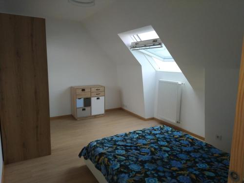 a small bedroom with a bed and a skylight at chambre d'hôte in Brest