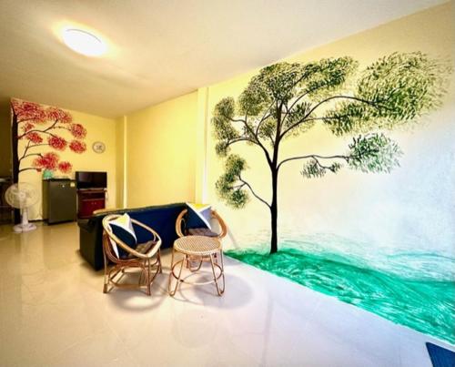 a living room with a tree mural on the wall at กรชวัล วิลล่า in Nakhon Pathom