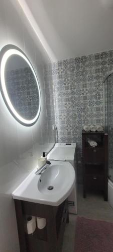 a bathroom with a white sink and a mirror at Apartament CityStation in Wałbrzych