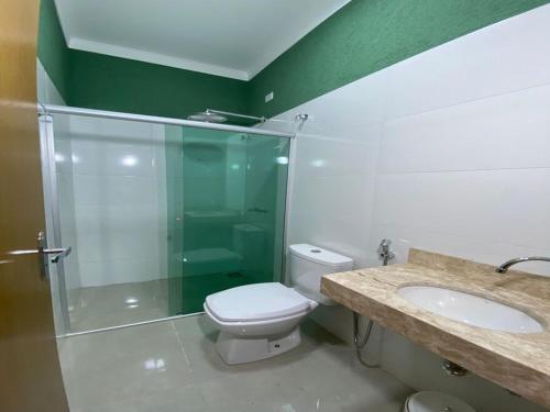 a bathroom with a shower and a toilet and a sink at AMPARO HOTEL in Ribas do Rio Pardo