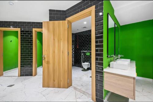 Appartement Dubai في دبي: حمام مع حوض وجدار أخضر