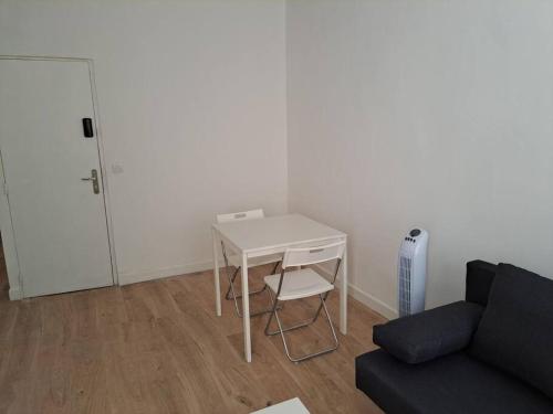 un salon avec une table blanche et un canapé dans l'établissement BudgetBnb 162, Studio opéra, à Toulon
