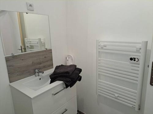 une salle de bain blanche avec un lavabo et un miroir dans l'établissement BudgetBnb 162, Studio opéra, à Toulon
