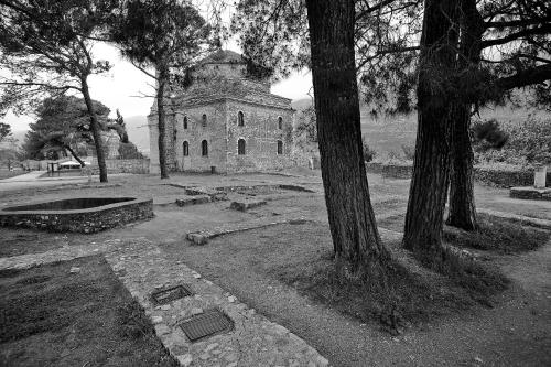 a black and white photo of an old building with trees at Hotel Kastro in Ioannina