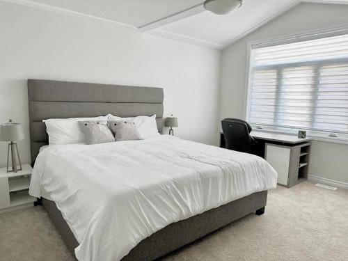 a white bedroom with a large bed and a desk at Luxury Detached House Kingston in Kingston