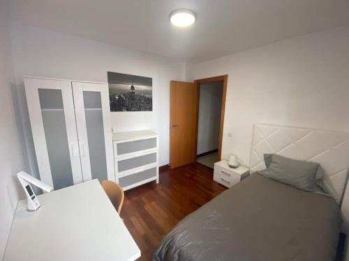 a bedroom with a white bed and a white cabinet at Bright lovely quiet flat very centric in SC in Santa Cruz de Tenerife