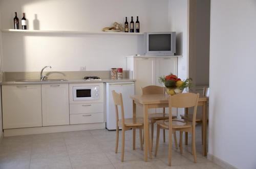 a kitchen with a table and chairs and a sink at Residence Castello Otranto in Otranto
