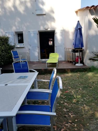 a table and chairs and an umbrella on a deck at ARRETEZ VOUS A OLERON in Le Château-dʼOléron